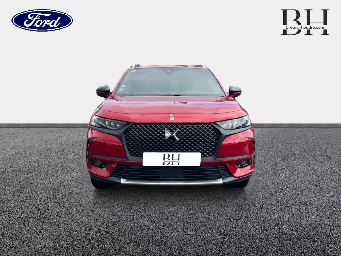 Vue frontale d'un DS7 Crossback rouge Absolu avec calandre noire et toit ouvrant panoramique visible.