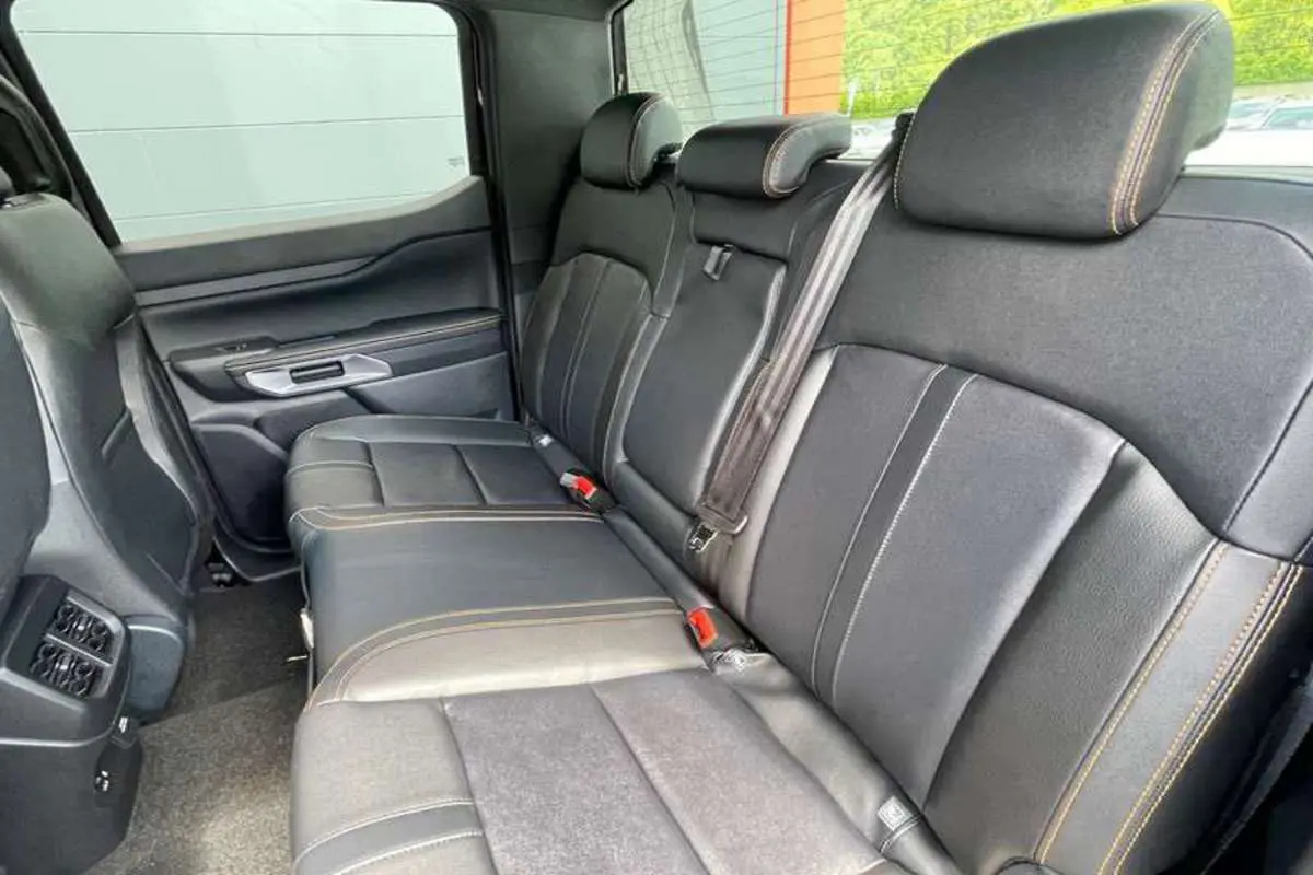 Vue intérieure arrière du Ford Ranger 2025 Wildtrak Plus, sièges en cuir noir agate avec surpiqûres contrastées.