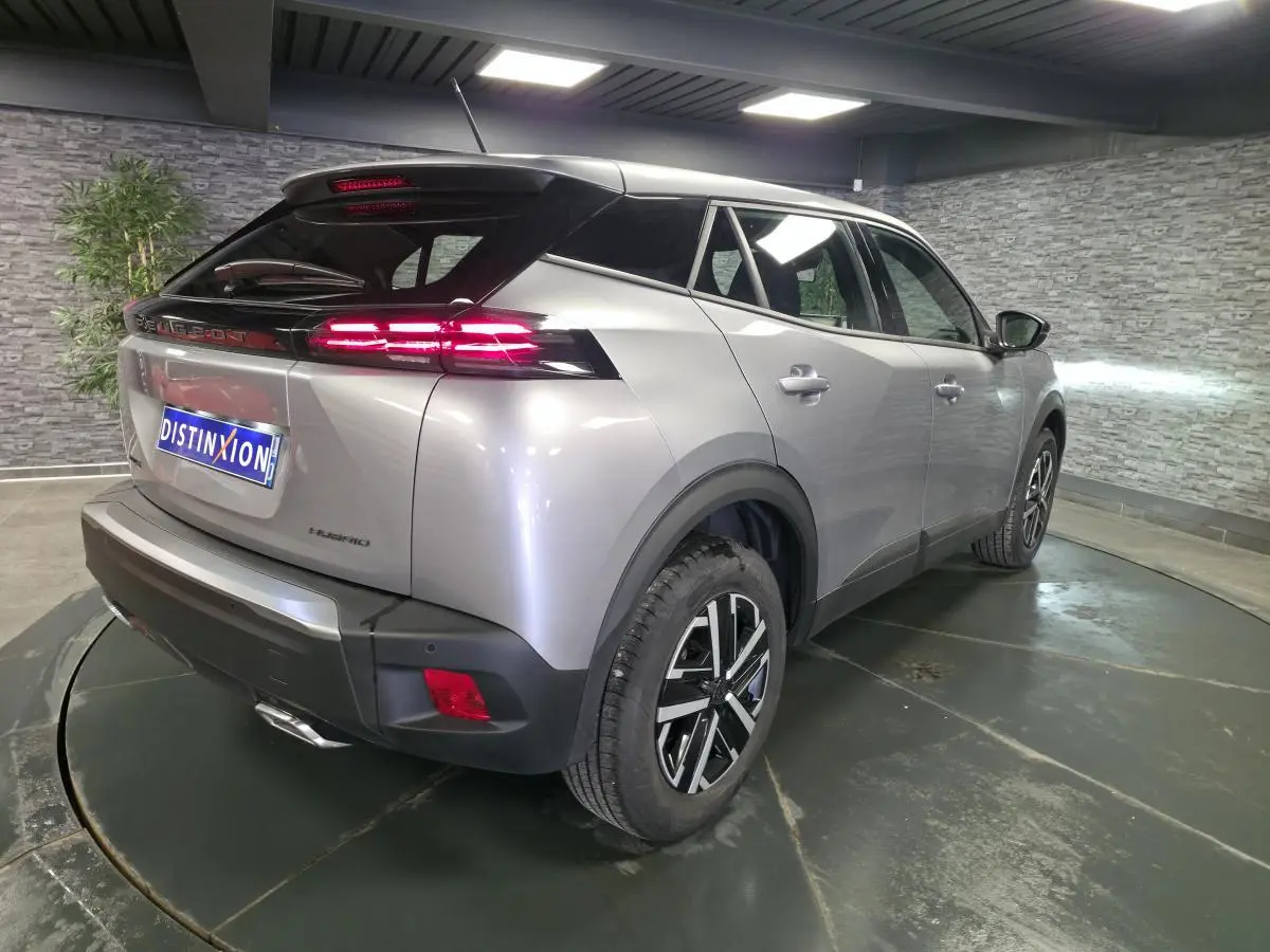 Vue 3/4 arrière droite d’un Peugeot 2008 gris métallisé avec feux arrière LED 3 griffes et jantes tôle 16 pouces.