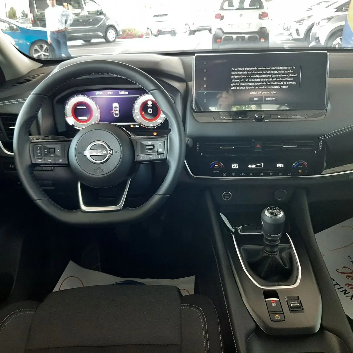 Vue intérieure du tableau de bord du Nissan Qashqai 2022 avec volant multifonction et écran tactile central allumé.