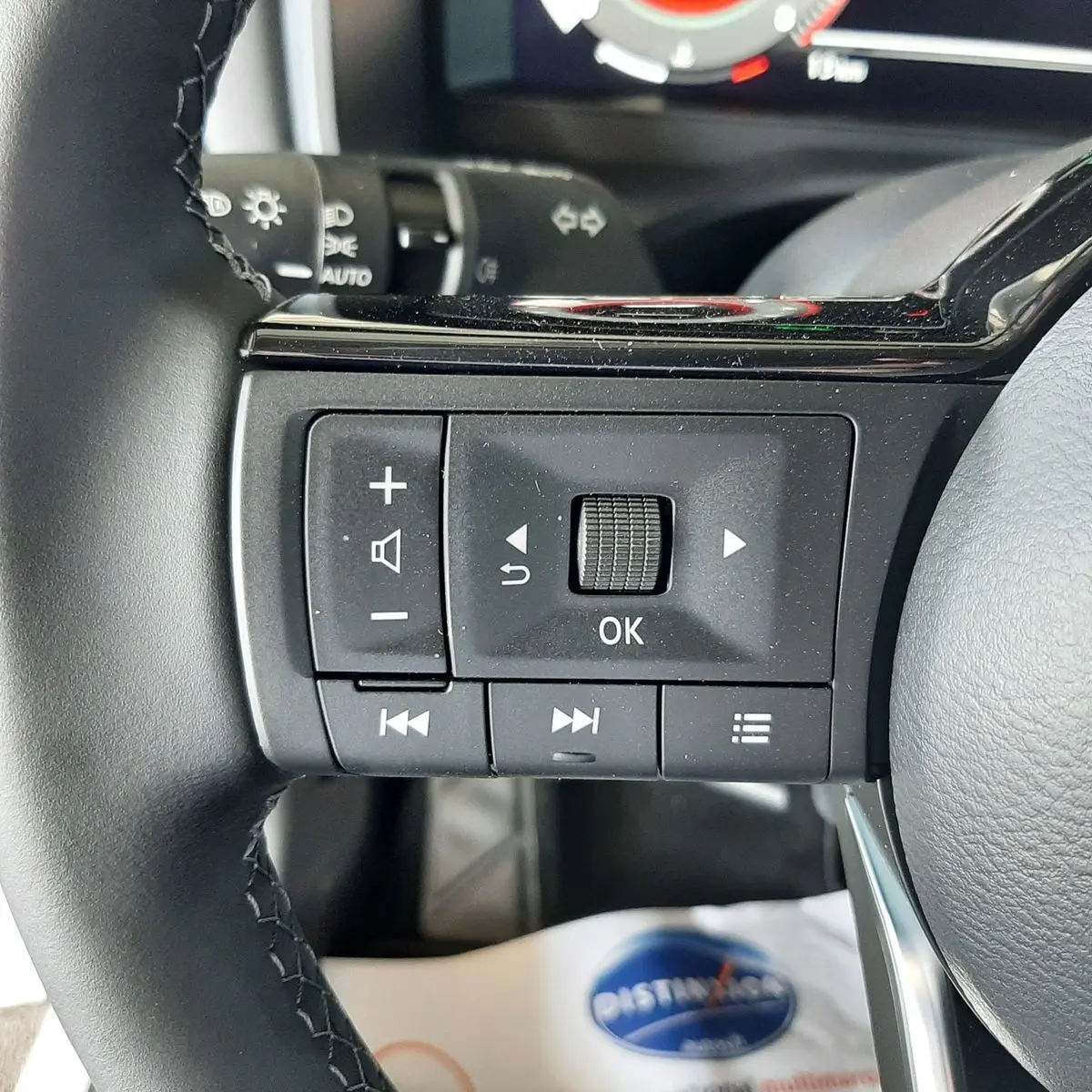 Gros plan sur les commandes multifonctions noires du volant du Nissan Qashqai blanc lunaire 2022.