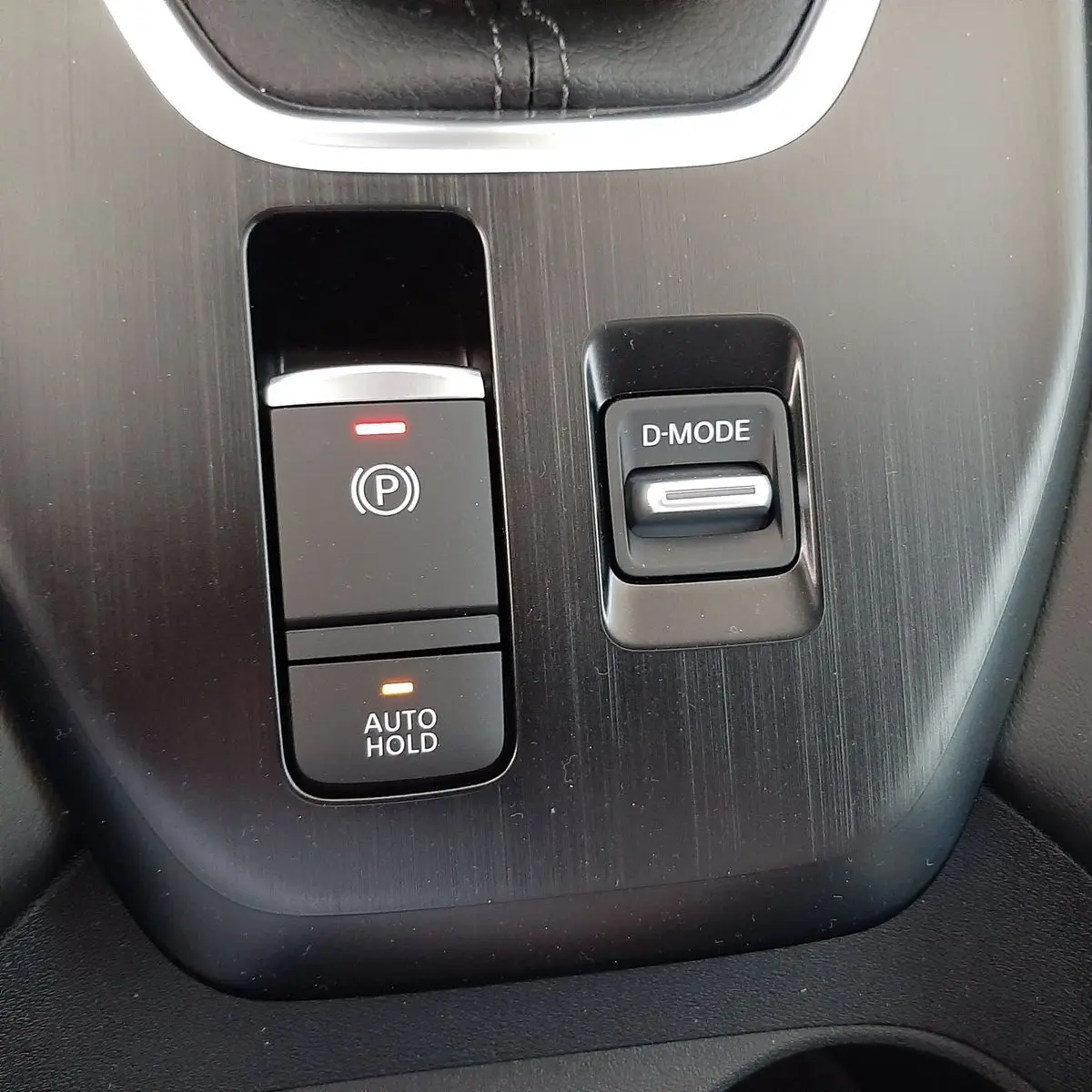 Gros plan sur les commandes D-MODE et frein à main électronique du Nissan Qashqai blanc lunaire 2022.