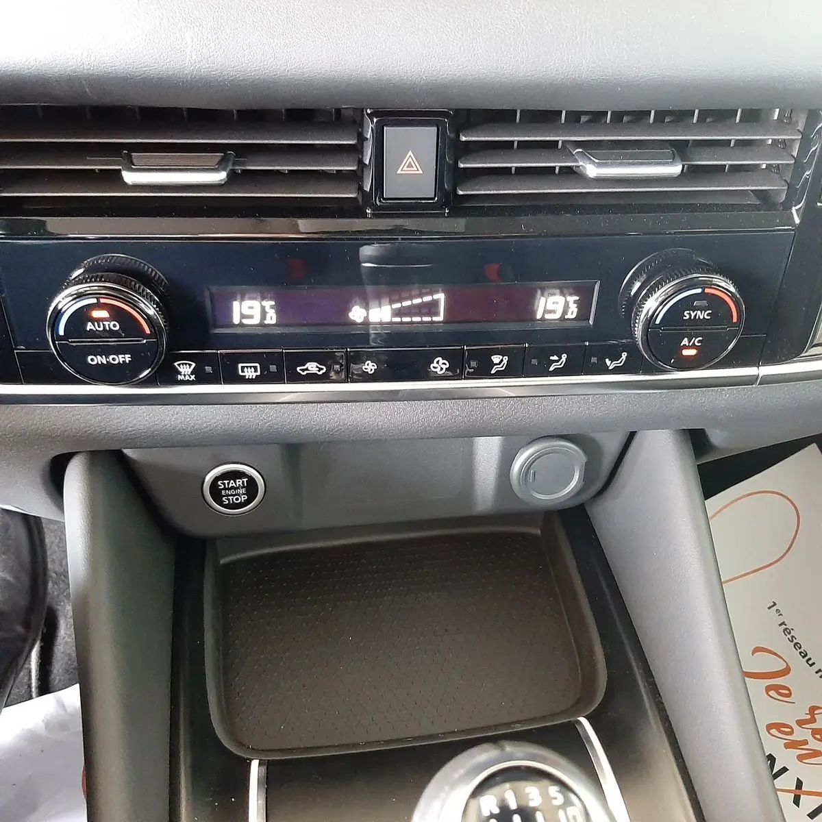 Tableau de bord du Nissan Qashqai 2022 montrant la climatisation digitale et le bouton start/stop en noir et gris.