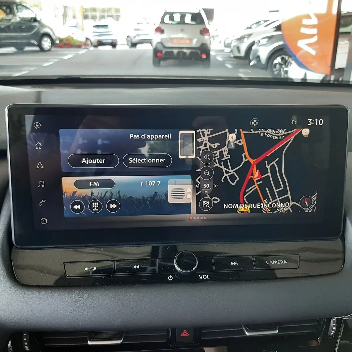Écran tactile central du Nissan Qashqai blanc lunaire 2022 montrant navigation et radio FM à l'arrêt en intérieur.