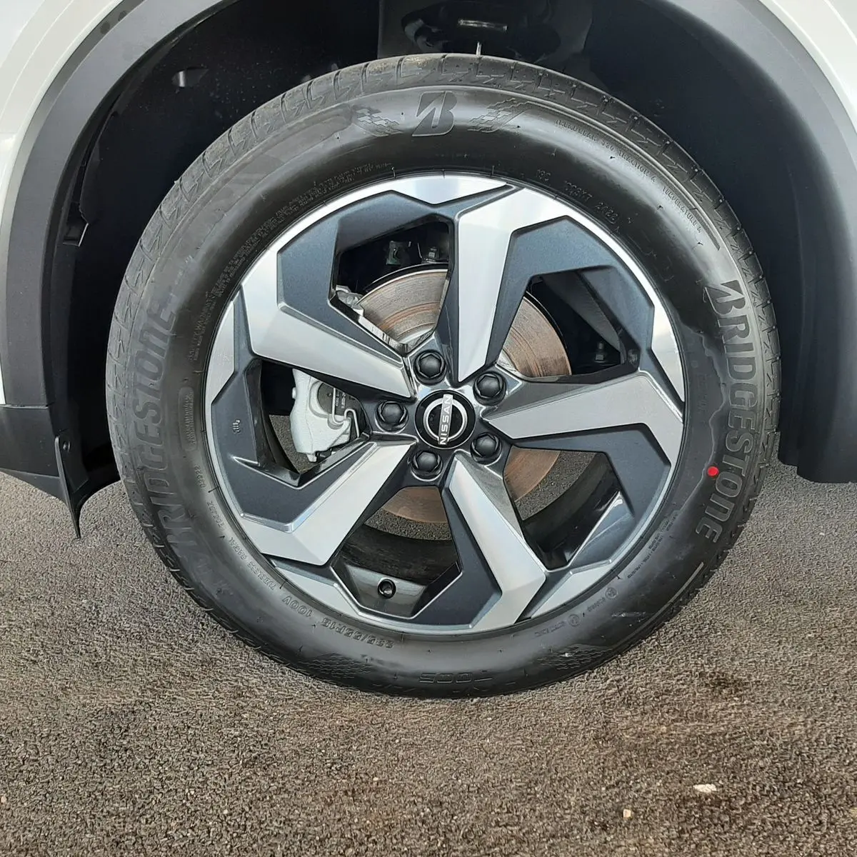 Gros plan sur la jante alliage bicolore et pneu Bridgestone du Nissan Qashqai blanc lunaire 2022.
