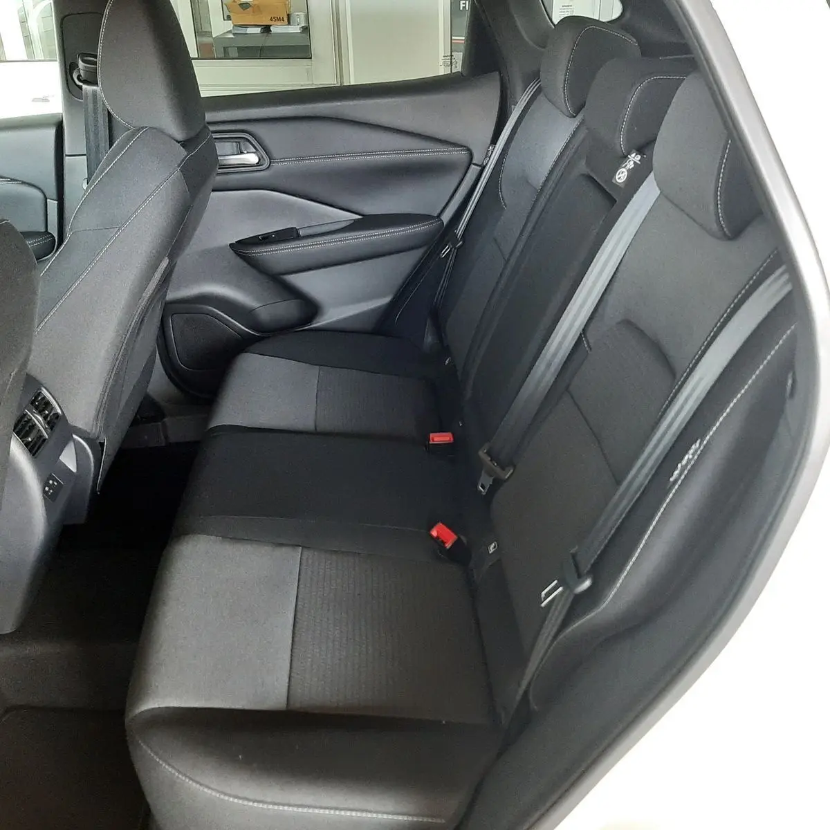 Vue intérieure côté droit des sièges arrière noirs en tissu du Nissan Qashqai blanc lunaire 2022 MILD HYBRID.