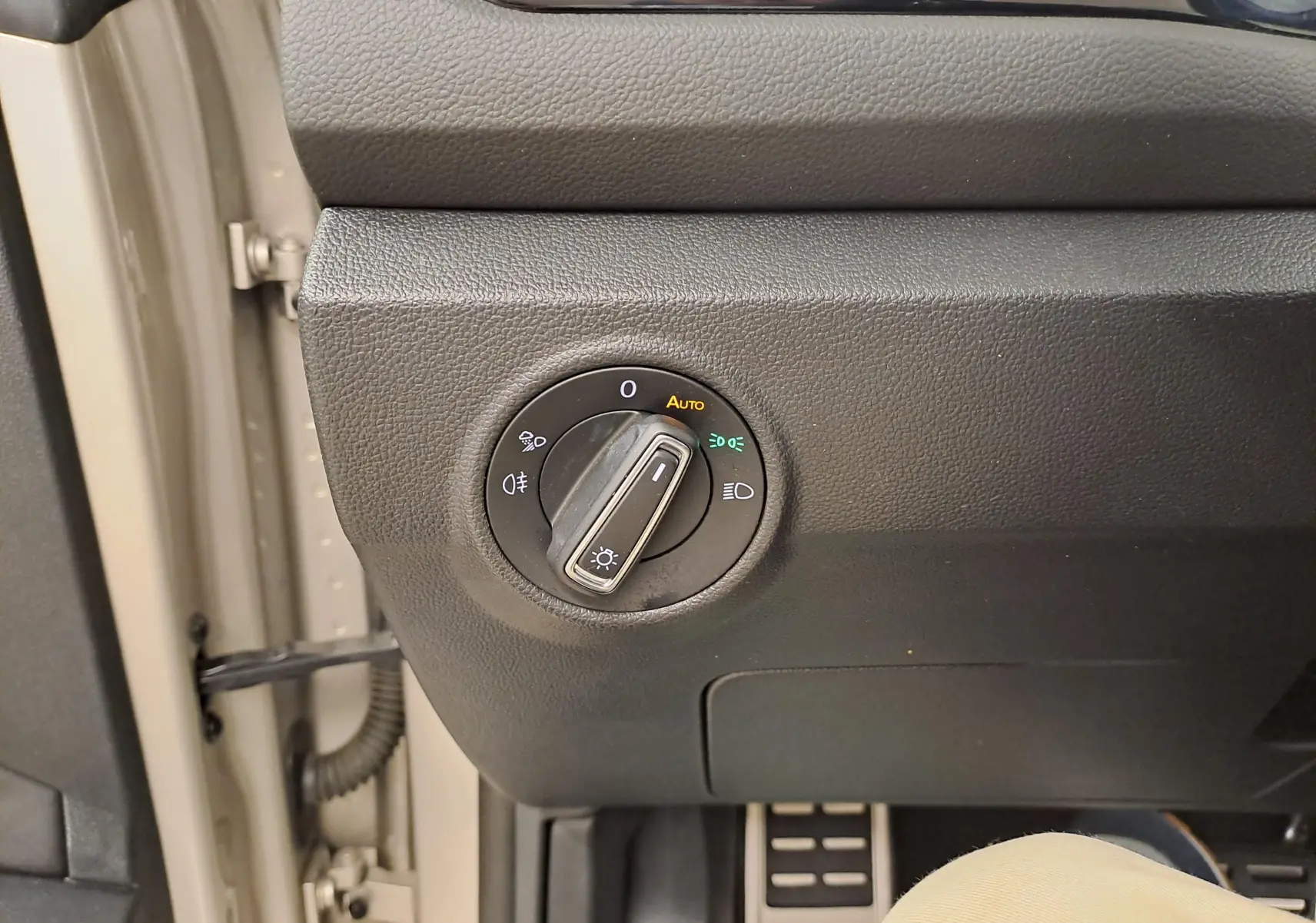 Détail du bouton de commande des phares sur le tableau de bord du Volkswagen T-Roc Cabriolet gris ivoire.