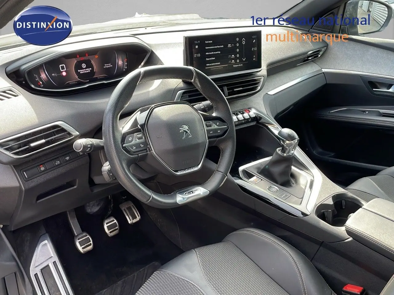 Intérieur moderne du Peugeot 3008 GT 2023, vue côté conducteur, volant compact et levier de vitesse manuel visibles.