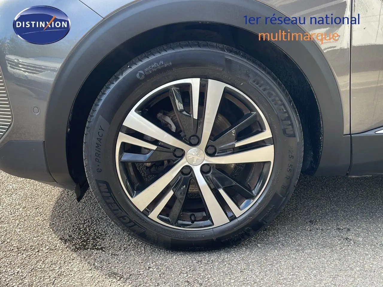 Gros plan sur la roue avant droite du Peugeot 3008 gris platinium avec jante alliage bicolore et pneu Michelin.