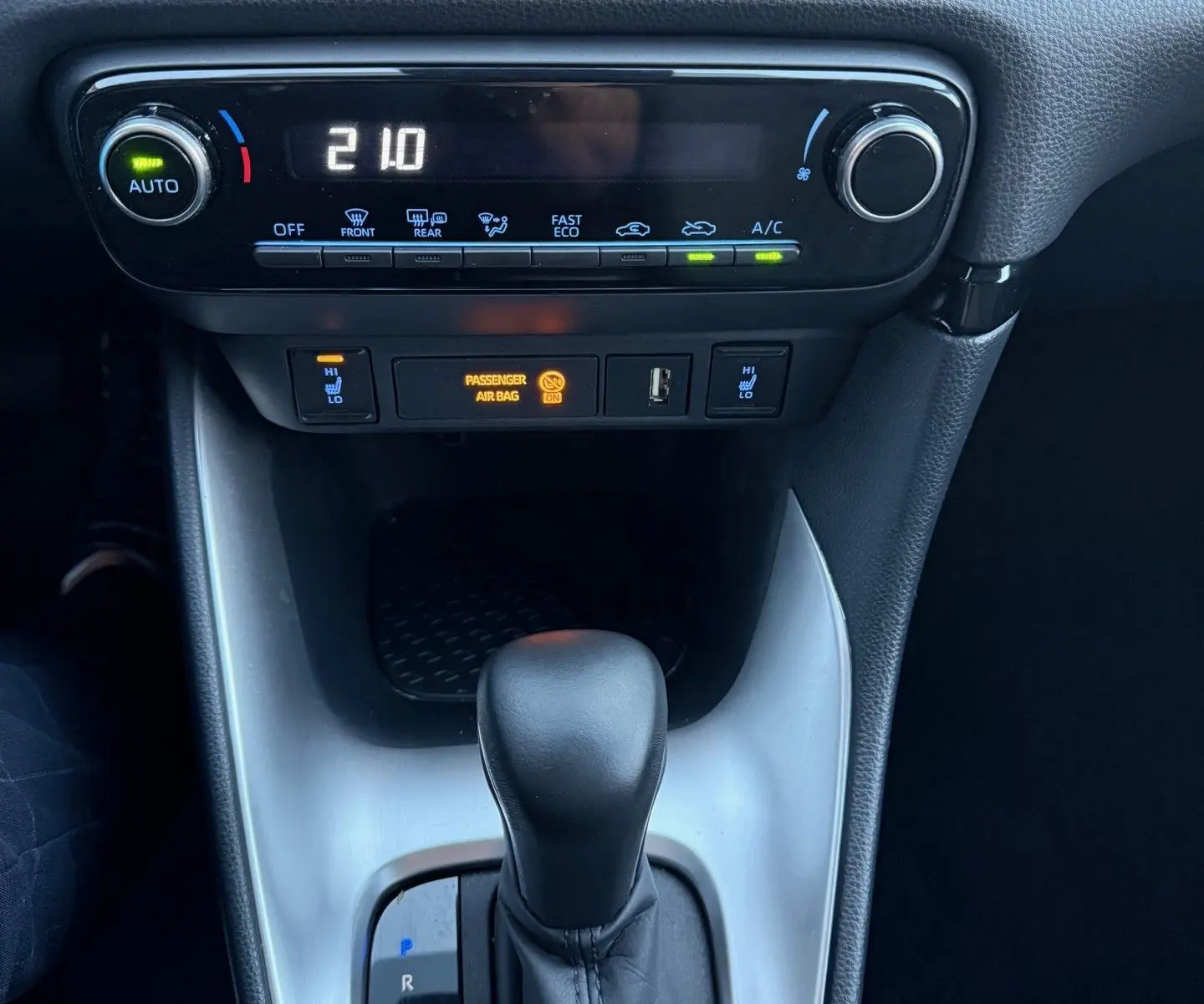 Vue rapprochée de la console centrale de la Toyota Yaris Hybride 2021, montrant la commande de climatisation et le levier de boîte automatique.