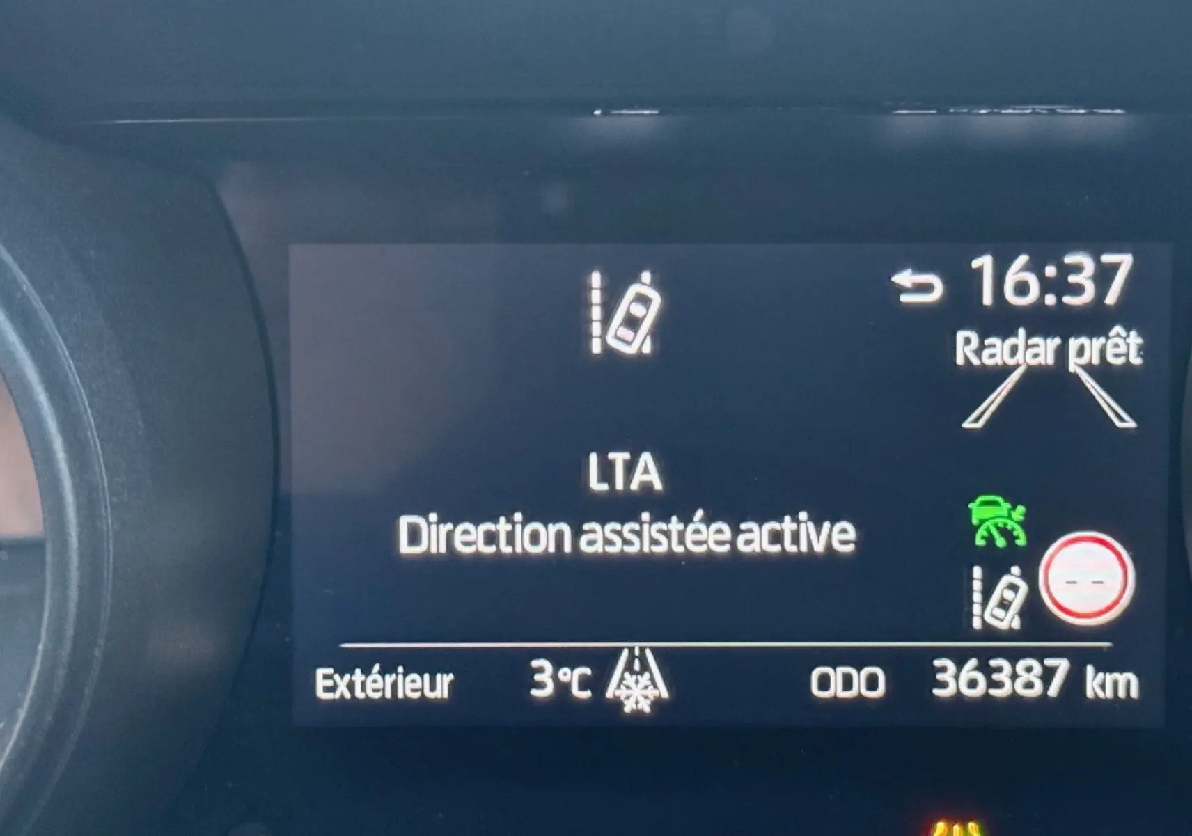 Affichage du tableau de bord de la Toyota Yaris Hybride 2021 montrant l'assistance de direction active et la température extérieure à 3°C.