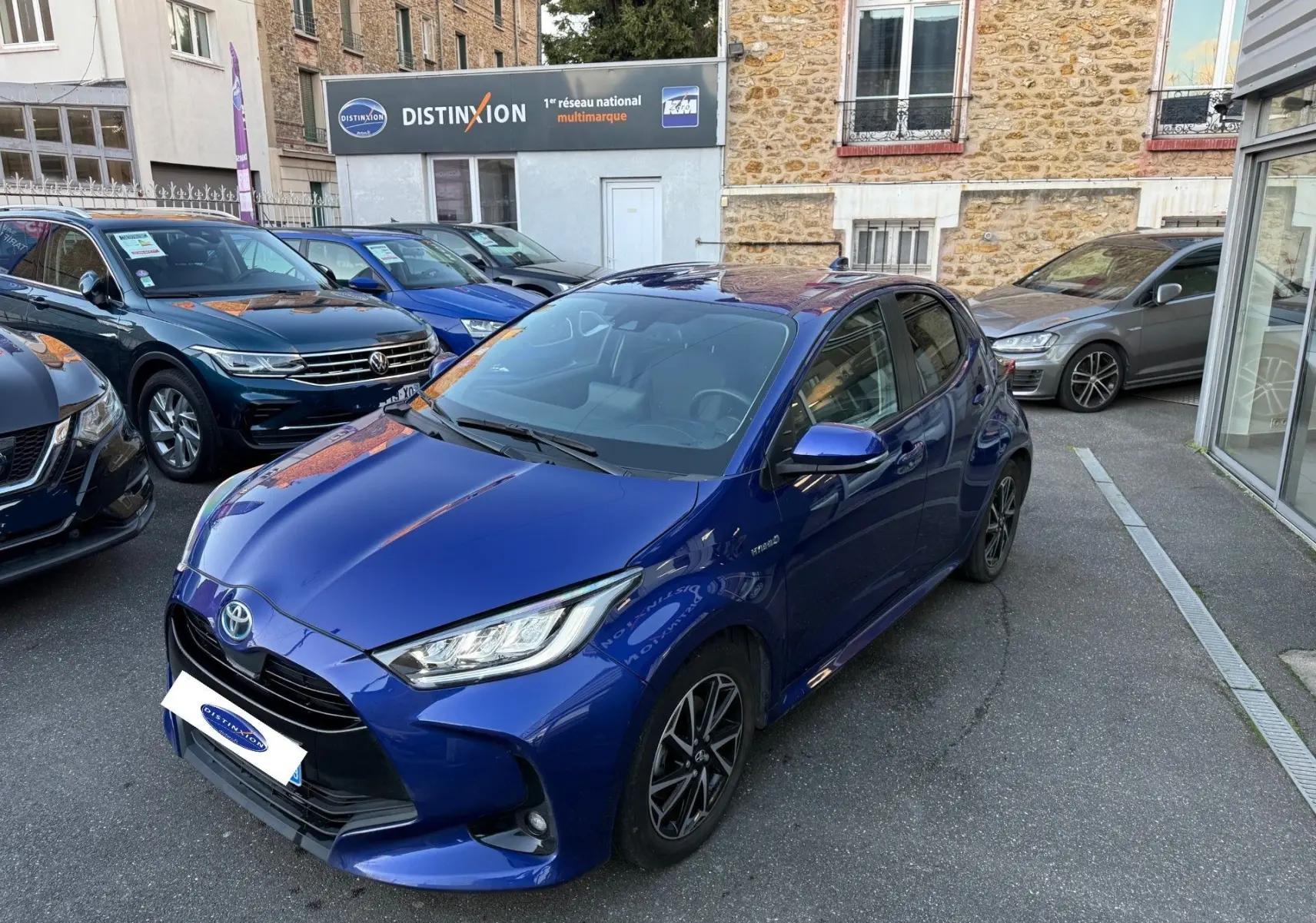 Toyota Yaris Hybride Design 116h bleu métal vue 3/4 avant droit avec phares LED et jantes noires en concession.