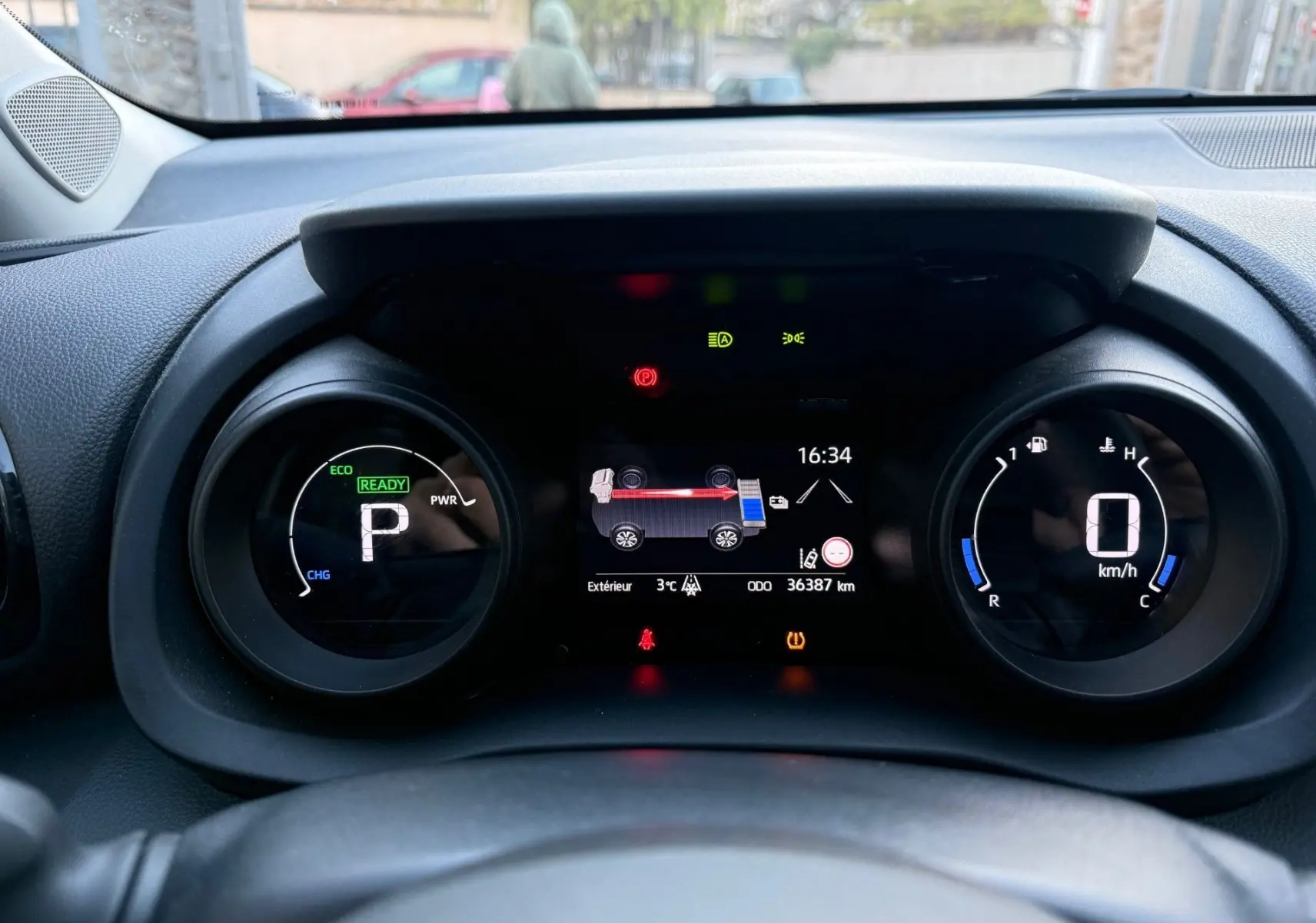 Tableau de bord numérique de la Toyota Yaris Hybride 2021, affichage mode parking et informations hybrides en vue frontale.