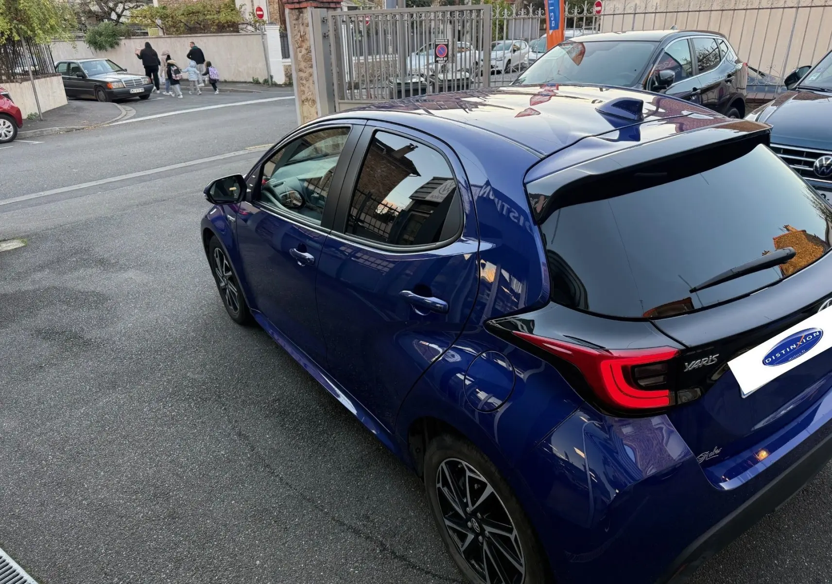 Vue 3/4 arrière droite d'une Toyota Yaris Hybride Design 116h bleu métal avec toit noir et feux LED distinctifs.