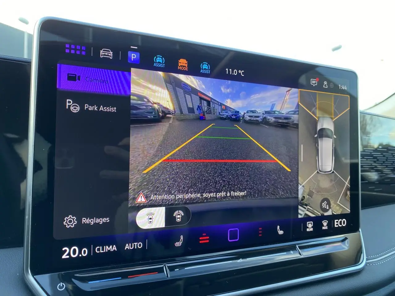 Écran tactile intérieur du Volkswagen Tiguan 2025 montrant l'assistance au stationnement avec vue caméra et affichage 3D.