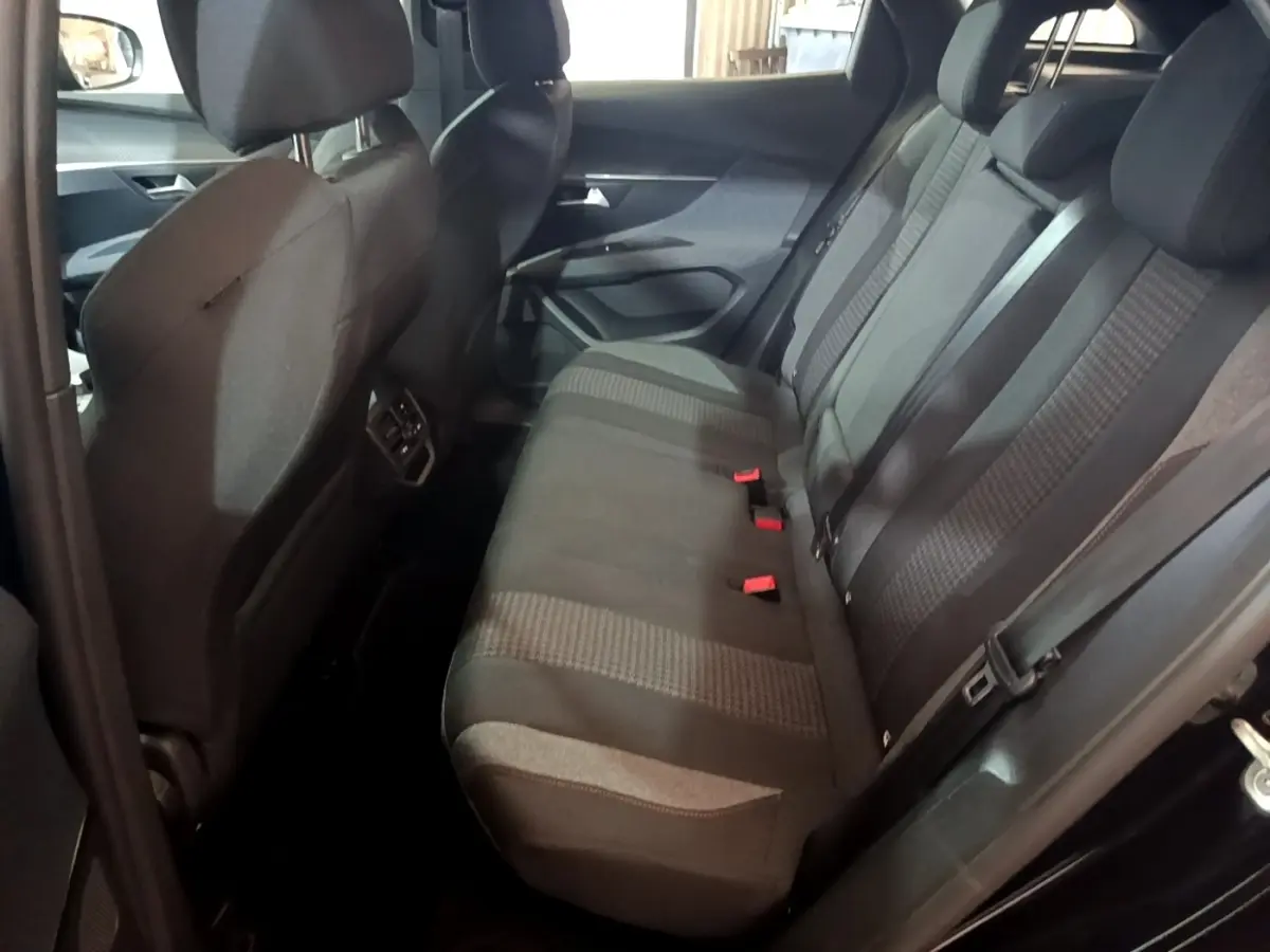 Vue intérieure côté droit des sièges arrière gris foncé du Peugeot 3008 noir, avec ceintures et appuie-têtes visibles.