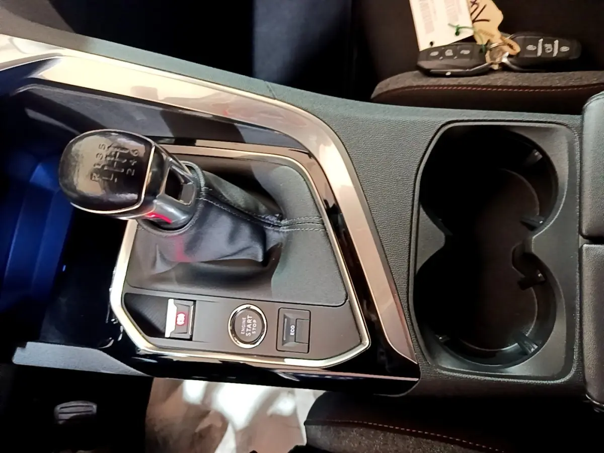 Vue rapprochée de la console centrale noire du Peugeot 3008 2022 avec levier de vitesse manuel et bouton démarrage.
