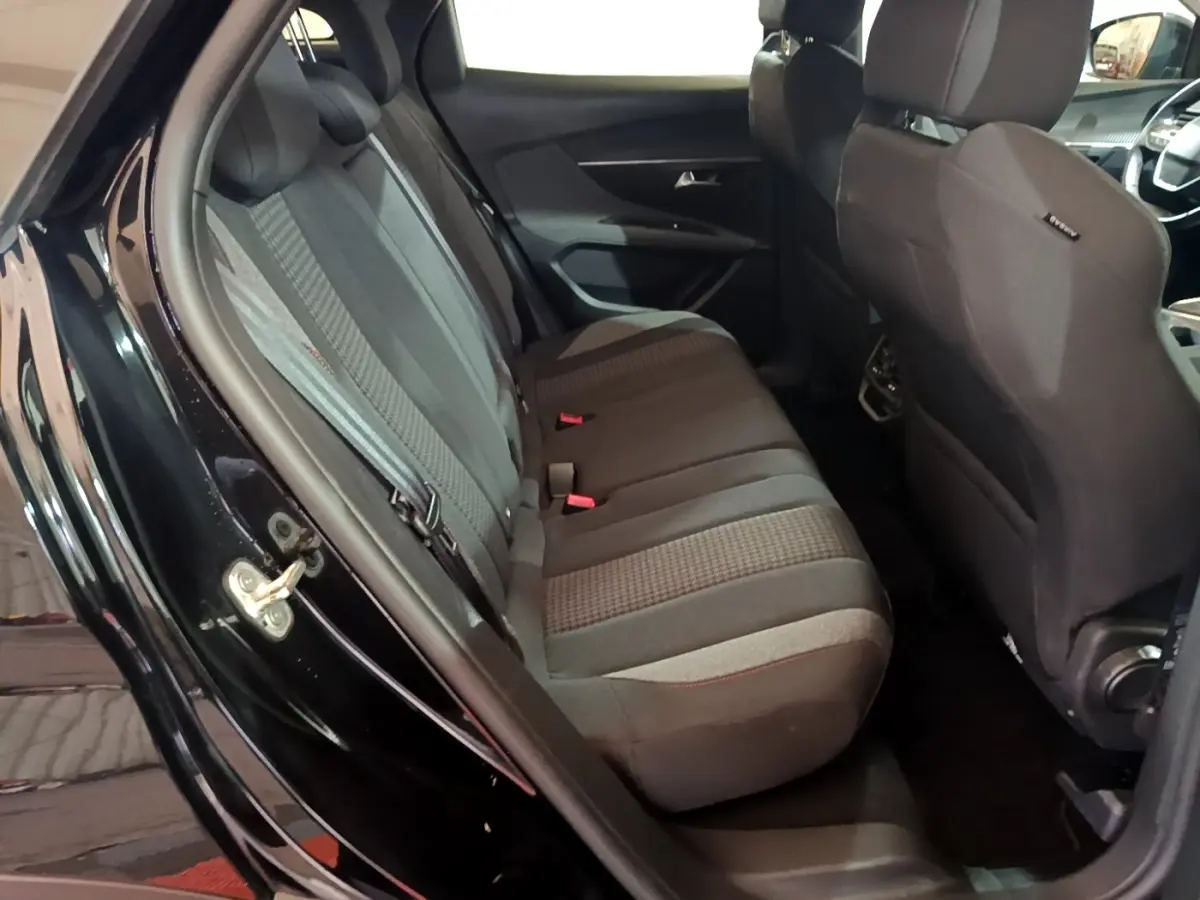 Vue intérieure côté gauche des sièges arrière noirs du Peugeot 3008 2022, tissu avec motifs et ceintures visibles.