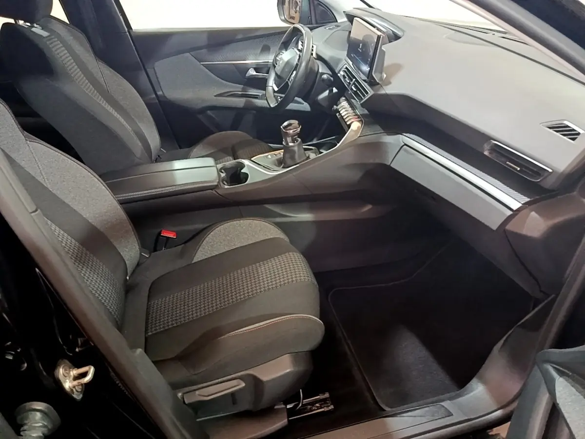 Vue intérieure côté passager du Peugeot 3008 noir 2022, avec tableau de bord moderne et boîte manuelle.