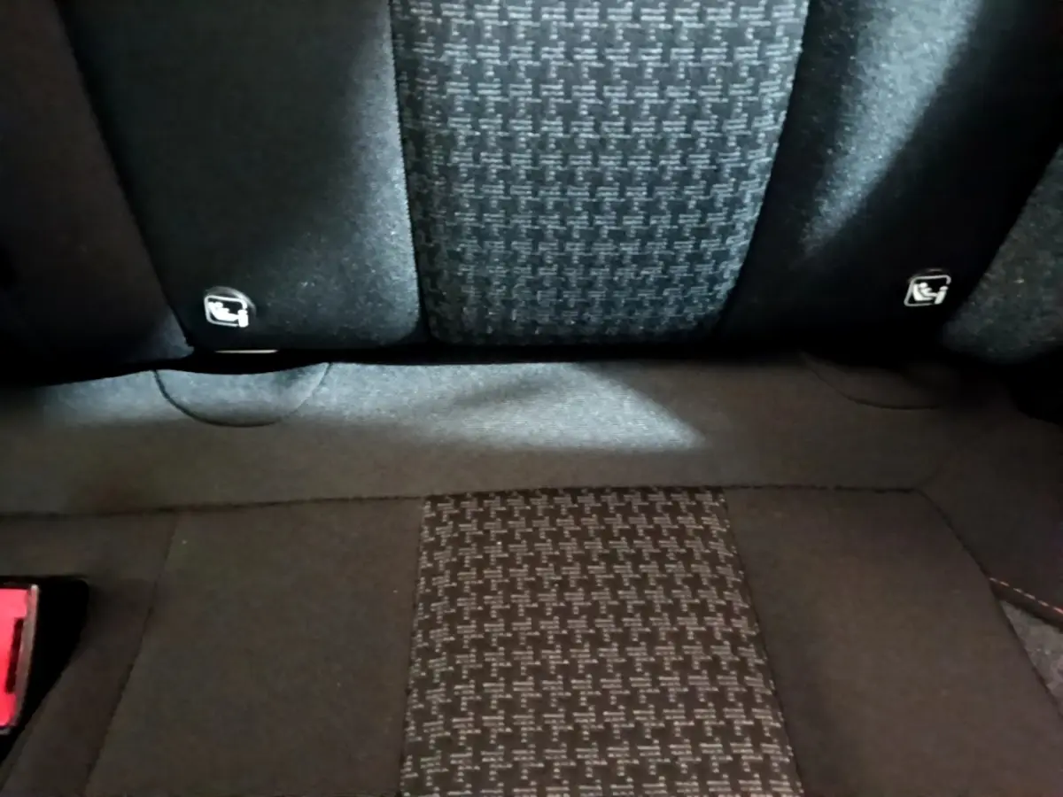 Gros plan sur la banquette arrière en tissu noir à motifs, avec fixation Isofix visible sur un Peugeot 3008 2022.