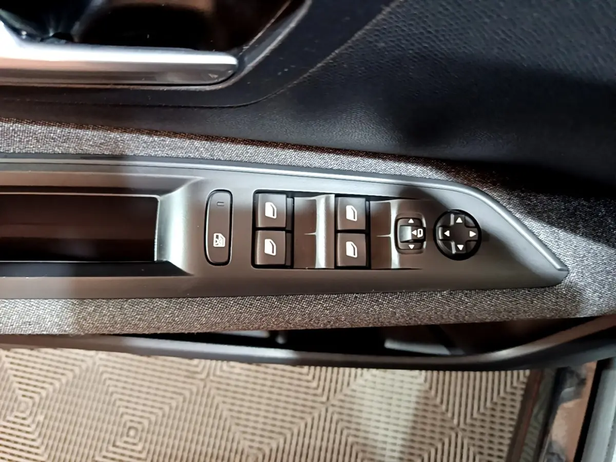 Vue rapprochée des commandes de lève-vitres et rétroviseurs côté gauche d’une Peugeot 3008 noir 2022.