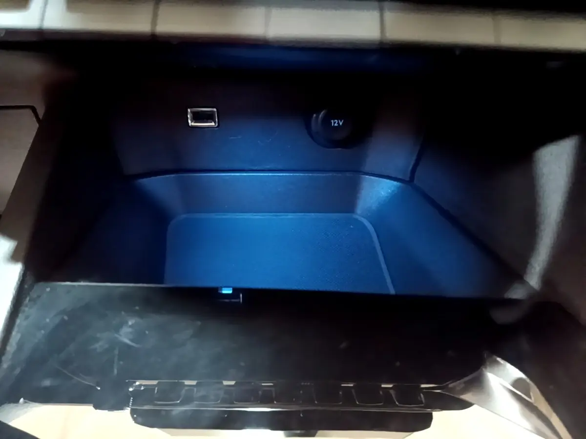 Gros plan de la prise USB et prise 12V dans le rangement intérieur du Peugeot 3008 noir, version 2022.