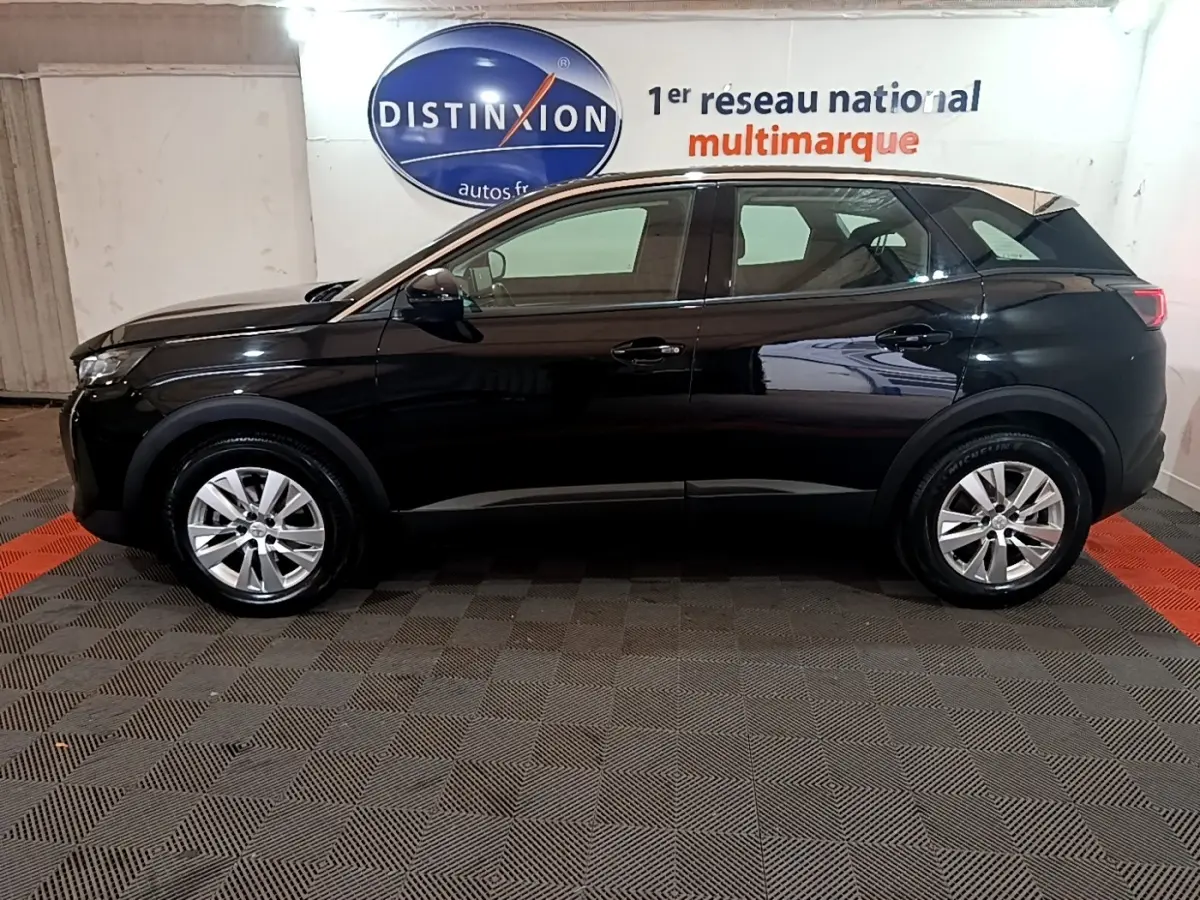 Profil côté gauche du Peugeot 3008 noir 2022 garé en intérieur avec jantes alliage et surface brillante.