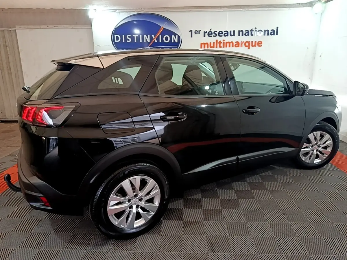 Vue latérale droite du Peugeot 3008 noir 2022 avec feux arrière allumés dans un showroom intérieur.