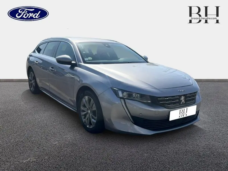 Peugeot 508 SW gris Artense vue 3/4 avant droit, break élégant avec calandre chromée et jantes alu.