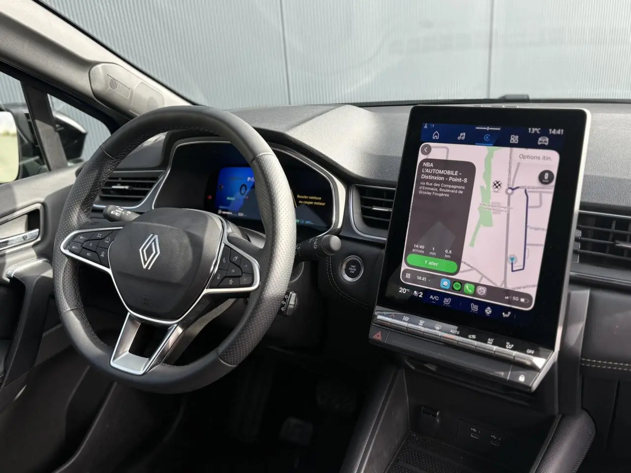 Vue intérieure du tableau de bord du Renault Symbioz 2025, avec écran tactile vertical et volant multifonction noir.