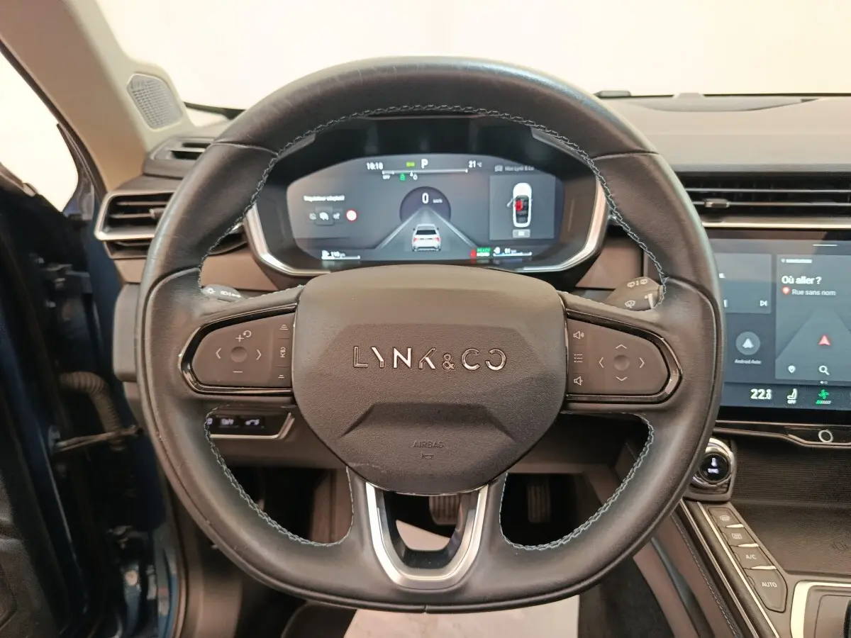 Vue rapprochée du volant noir du Lynk & Co 01 avec tableau de bord numérique et écran tactile central visible.