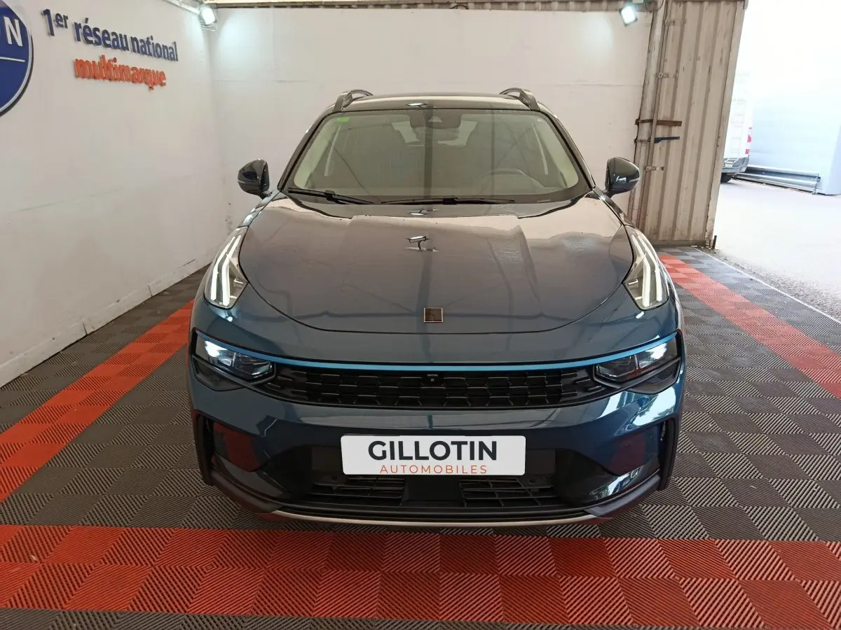 Vue frontale d'un SUV Link & Co 01 bleu avec phares LED distinctifs et calandre noire dans un garage.