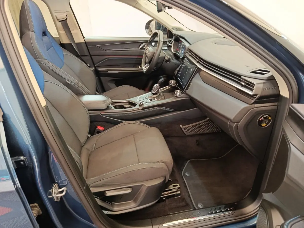 Vue intérieure côté passager avant du Lynk & Co 01 bleu, avec sièges bi-matière et tableau de bord moderne.