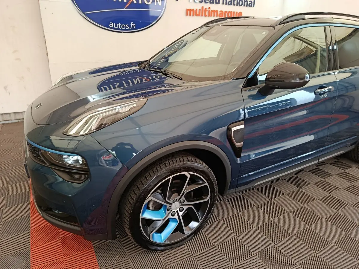 Vue 3/4 avant gauche du SUV hybride rechargeable LINK & CO 01 bleu avec jantes bicolores et détails noirs.