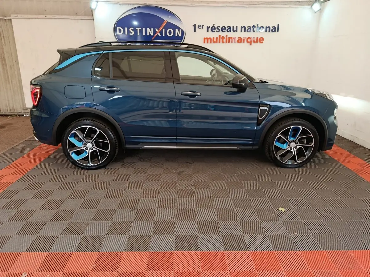 Vue de profil côté gauche d'un SUV LINK & CO 01 hybride rechargeable bleu avec jantes bicolores et toit noir.