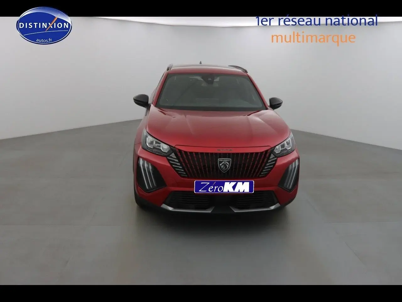 Peugeot 2008 rouge Elixir Metal vue de face dans un studio, avec calandre noire et feux LED distinctifs.