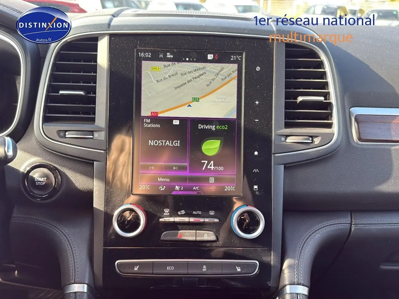 Tableau de bord noir du Renault Koleos 2017 avec écran tactile central affichant GPS et commandes climatisation.