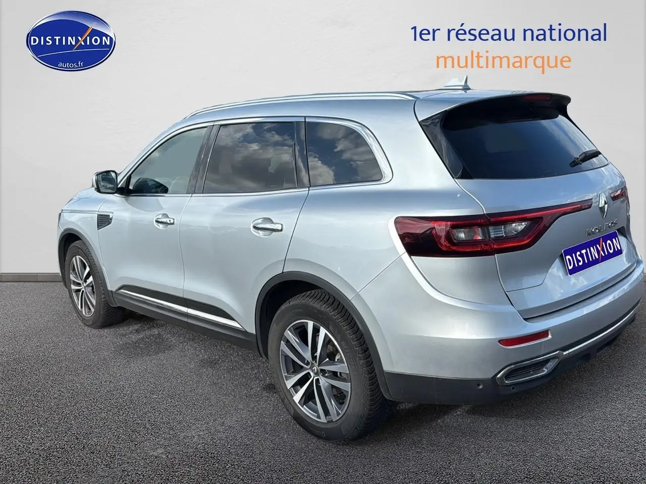 Renault Koleos gris en vue 3/4 arrière droit, avec vitres arrière surteintées et jantes alliage modernes.