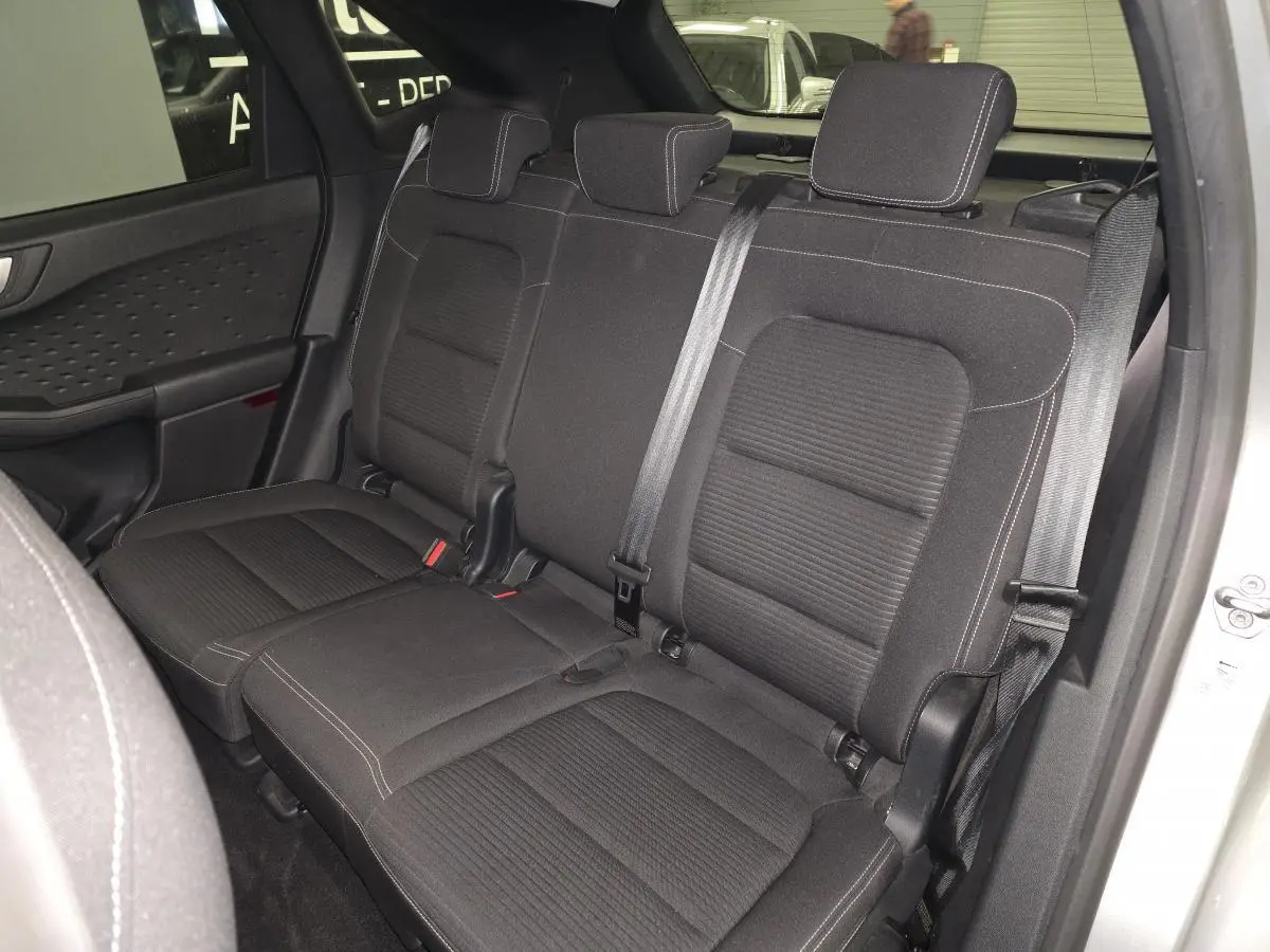 Vue intérieure des sièges arrière en tissu noir du Ford Kuga gris 2021, avec ceintures de sécurité et appuie-têtes visibles.