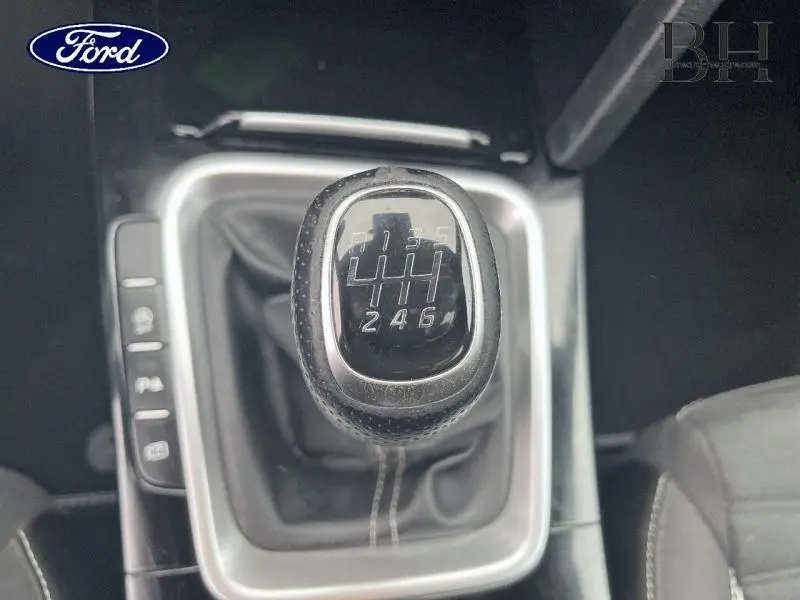 Gros plan sur le levier de vitesses manuel noir avec coutures blanches, intérieur sombre d'une KIA CEE'D 2023.