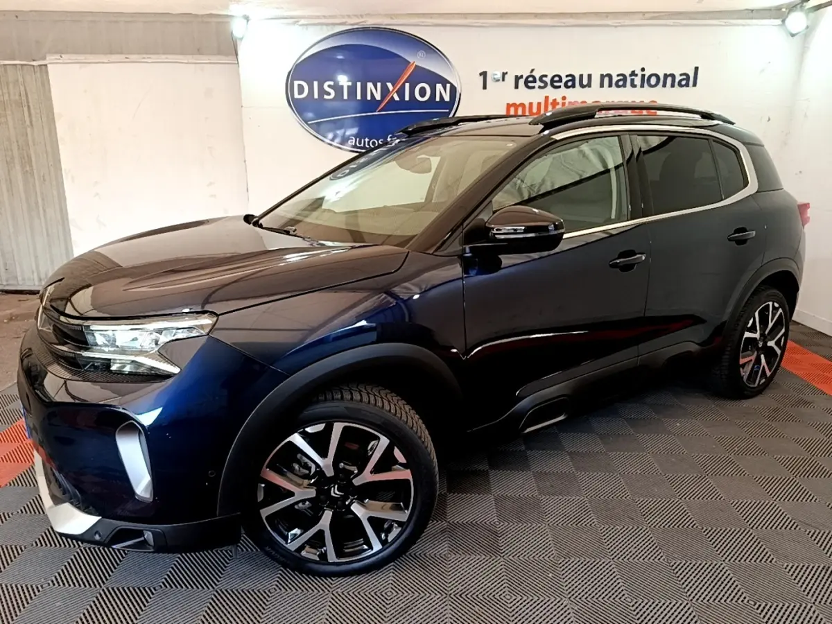 SUV Citroën C5 Aircross bleu foncé vu de trois quarts avant droit, avec jantes alliage et barres de toit noires.