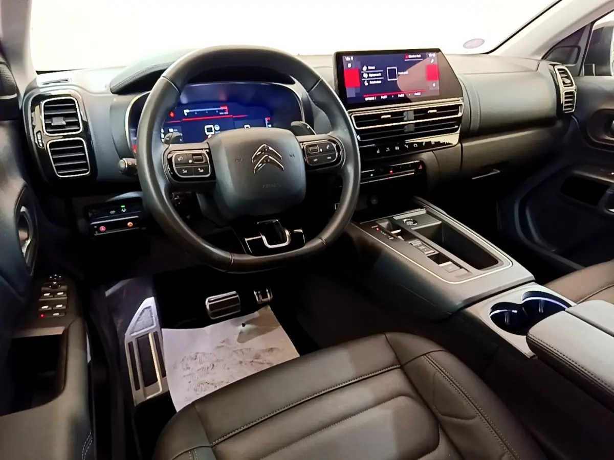 Intérieur noir du Citroën C5 Aircross 2023, vue depuis le siège conducteur sur le tableau de bord et l’écran tactile central.