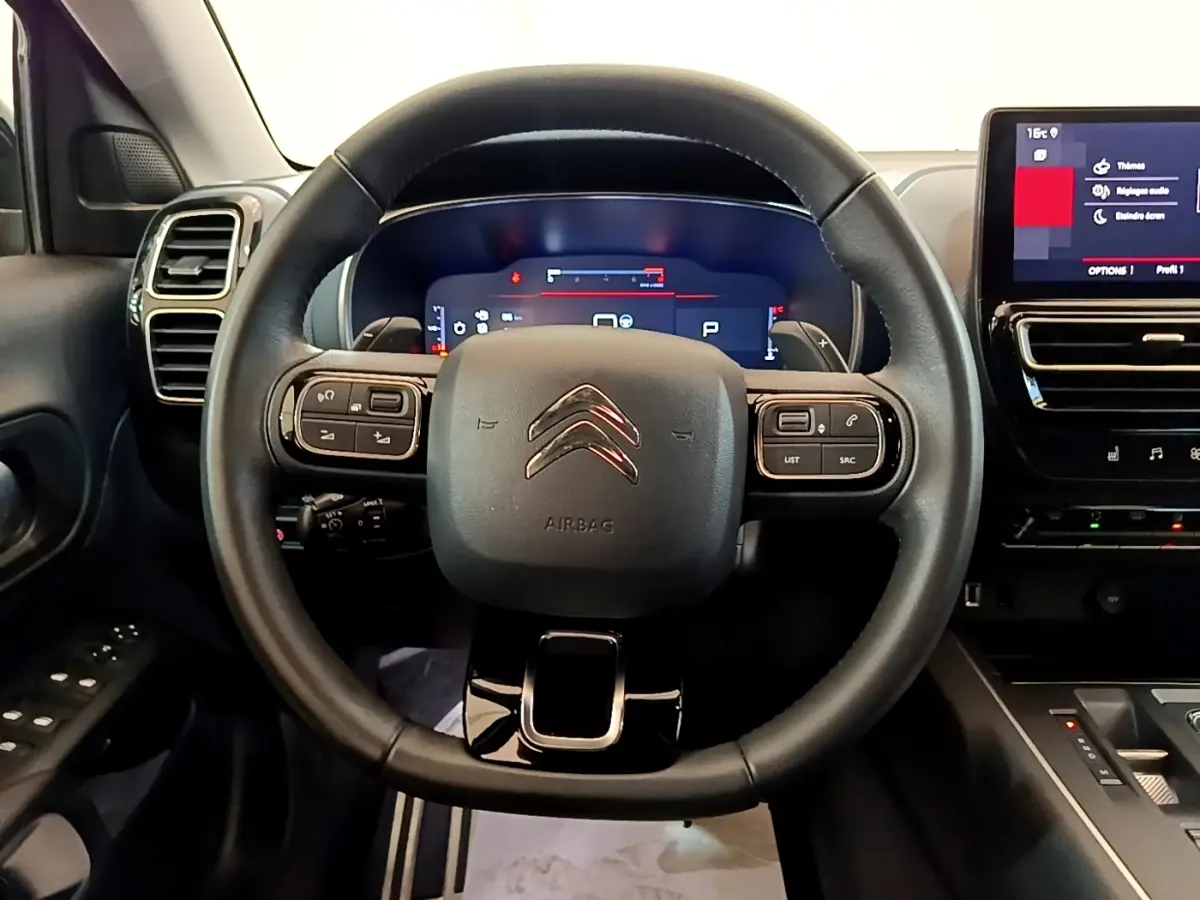 Vue centrée sur le volant cuir noir du Citroën C5 Aircross 2023 avec tableau de bord digital et écran tactile latéral.