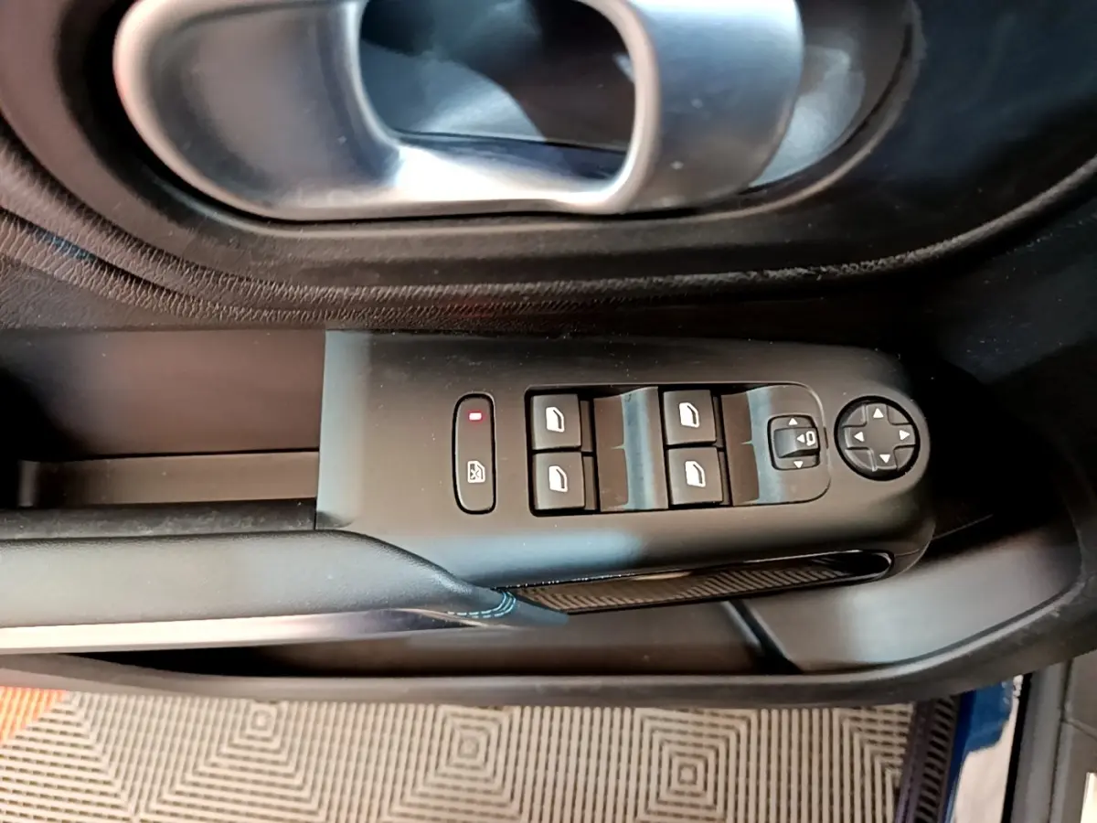 Vue rapprochée du panneau de commandes des vitres et rétroviseurs côté conducteur d'un Citroën C5 Aircross 2023, intérieur noir.