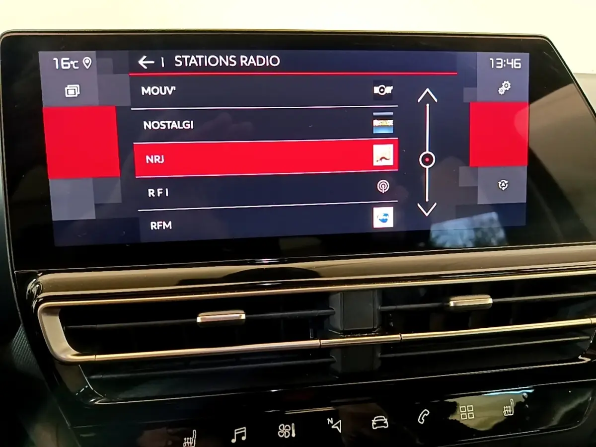 Écran tactile central du tableau de bord du Citroën C5 Aircross 2023 affichant les stations radio, avec commandes de ventilation en dessous.