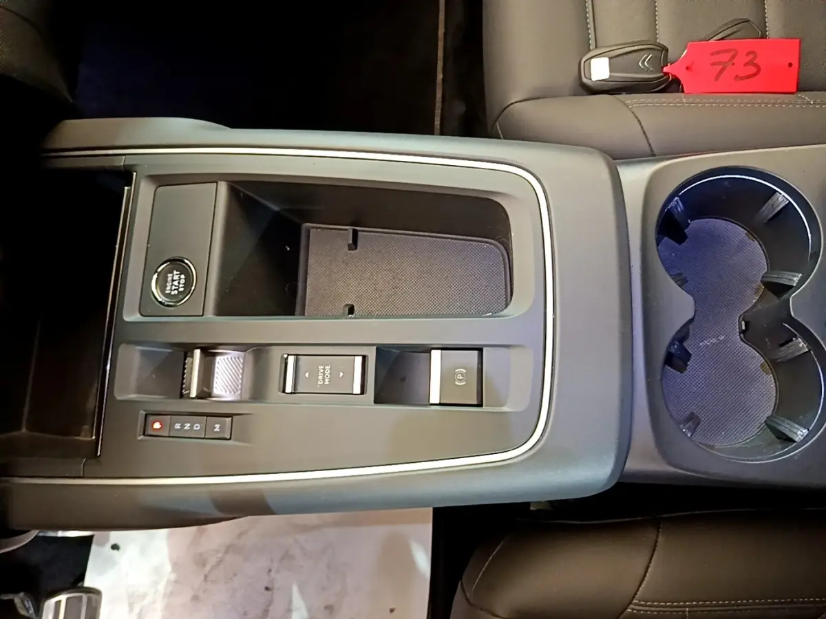 Vue plongeante sur la console centrale noire du Citroën C5 Aircross 2023 avec bouton start/stop et porte-gobelets.