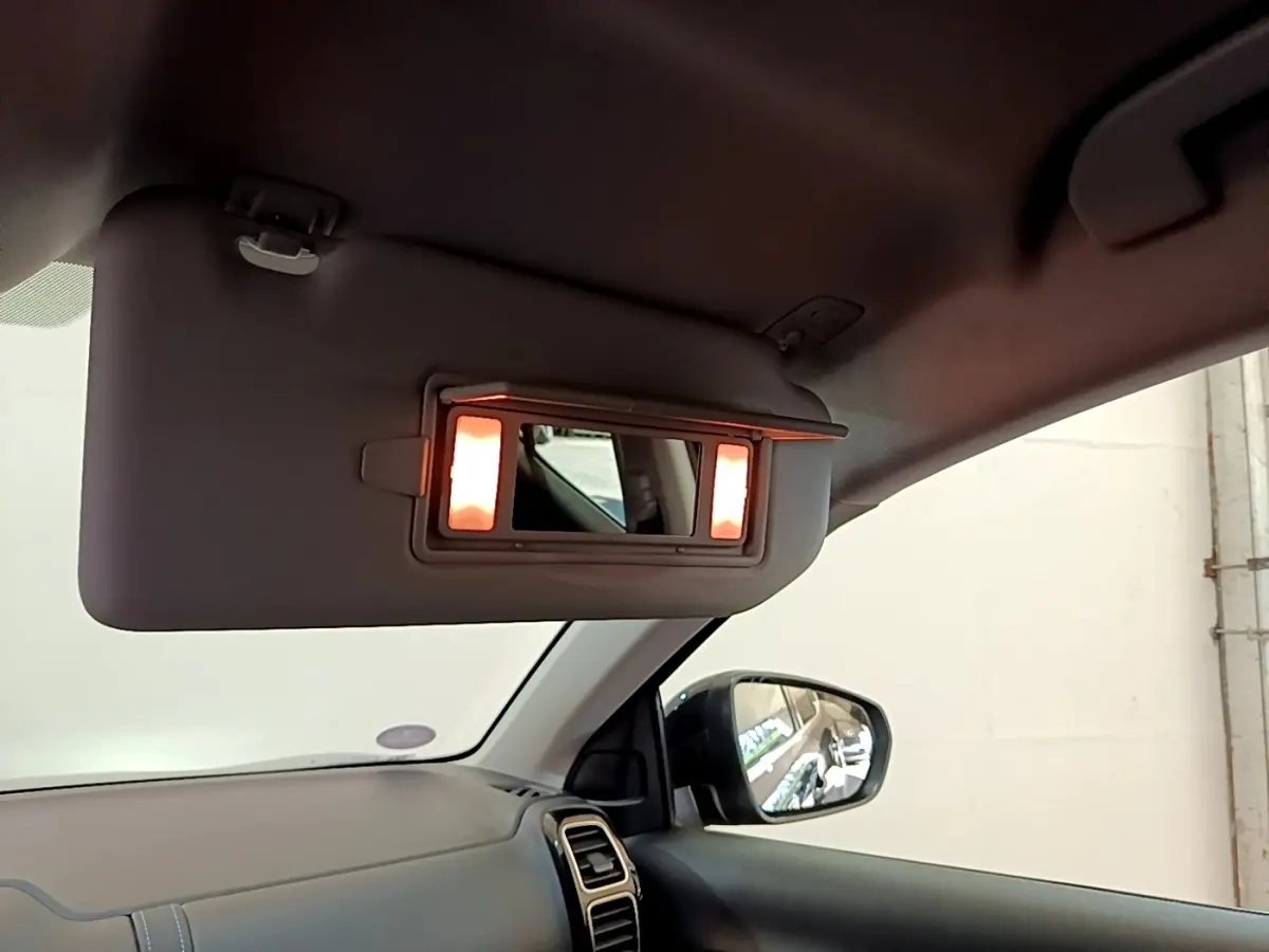 Intérieur du Citroën C5 Aircross 2023, vue côté passager avec pare-soleil rabattable et miroir éclairé.