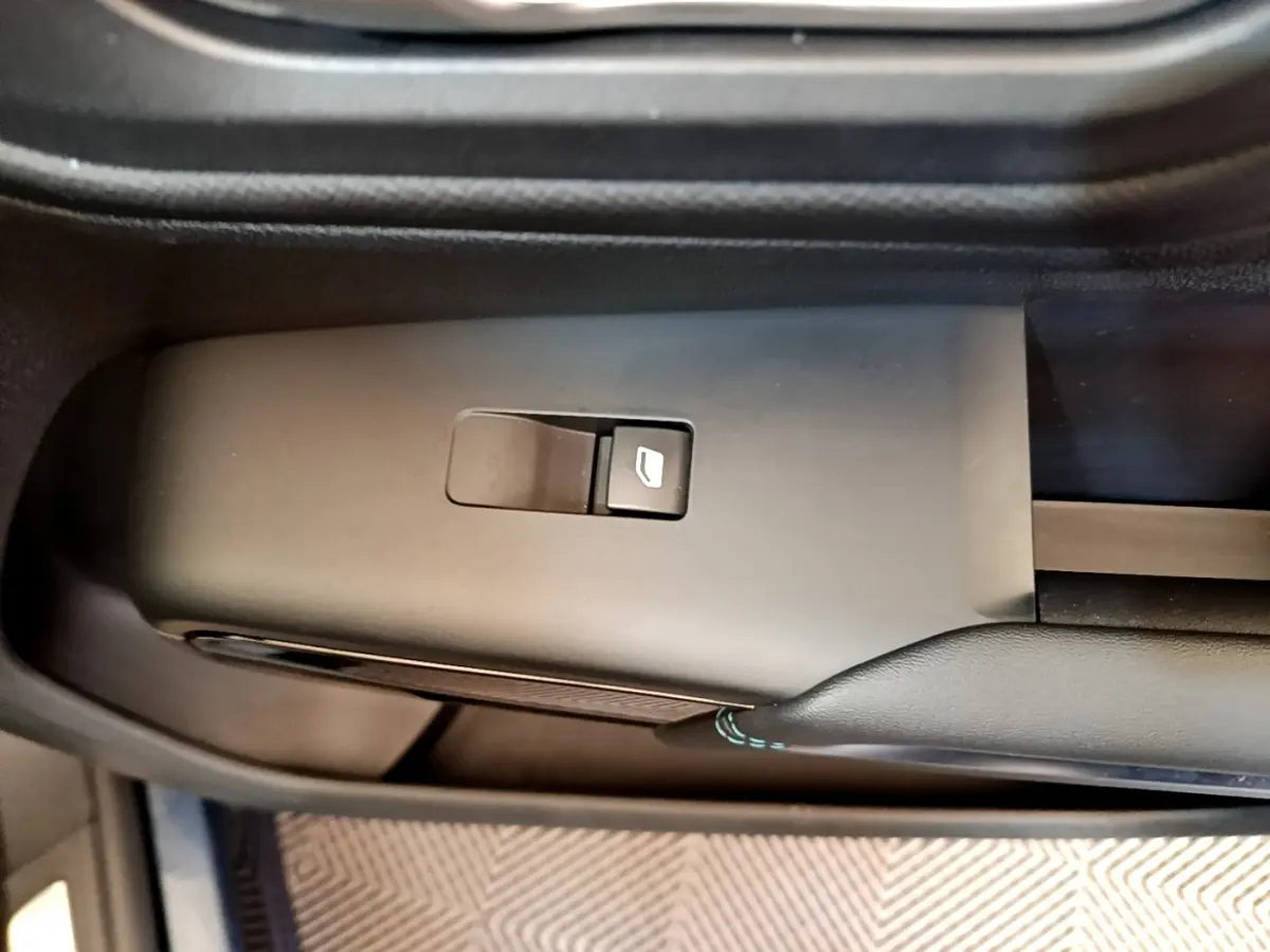 Gros plan sur le bouton de commande de la vitre électrique côté conducteur du Citroën C5 Aircross 2023, intérieur noir.