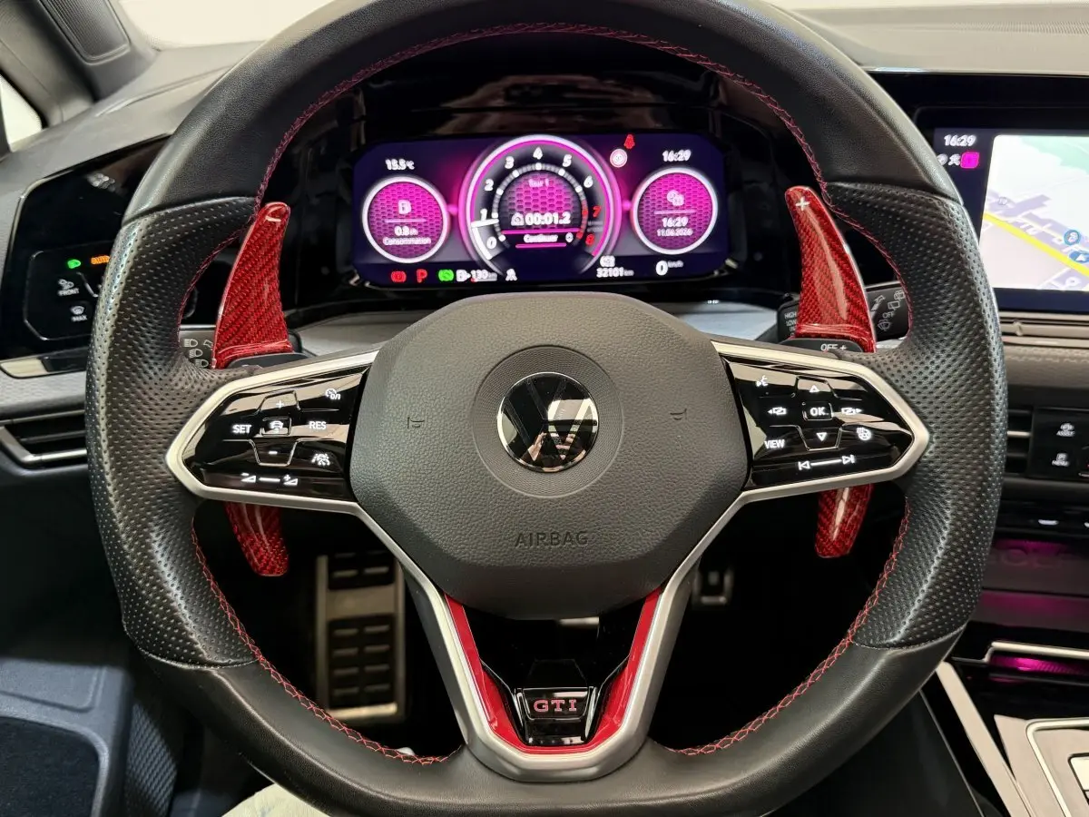 Vue rapprochée du volant perforé noir avec surpiqûres rouges et palettes rouges de la Volkswagen Golf GTI Clubsport 2022.