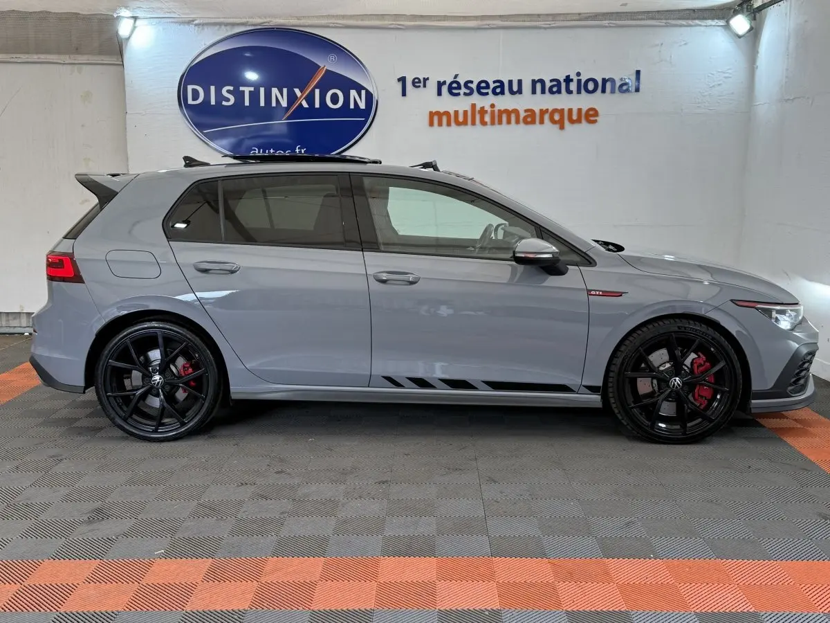 Vue latérale droite d'une Volkswagen Golf GTI Clubsport 2.0 TSI gris foncé avec jantes noires et étriers rouges.